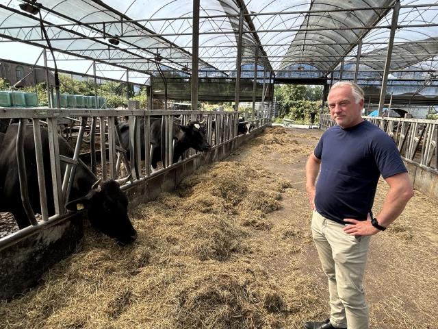 Portret van boer Fred van der Wart in zijn stal met koeien.