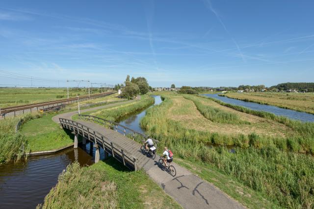 Fietsers met water en weiland